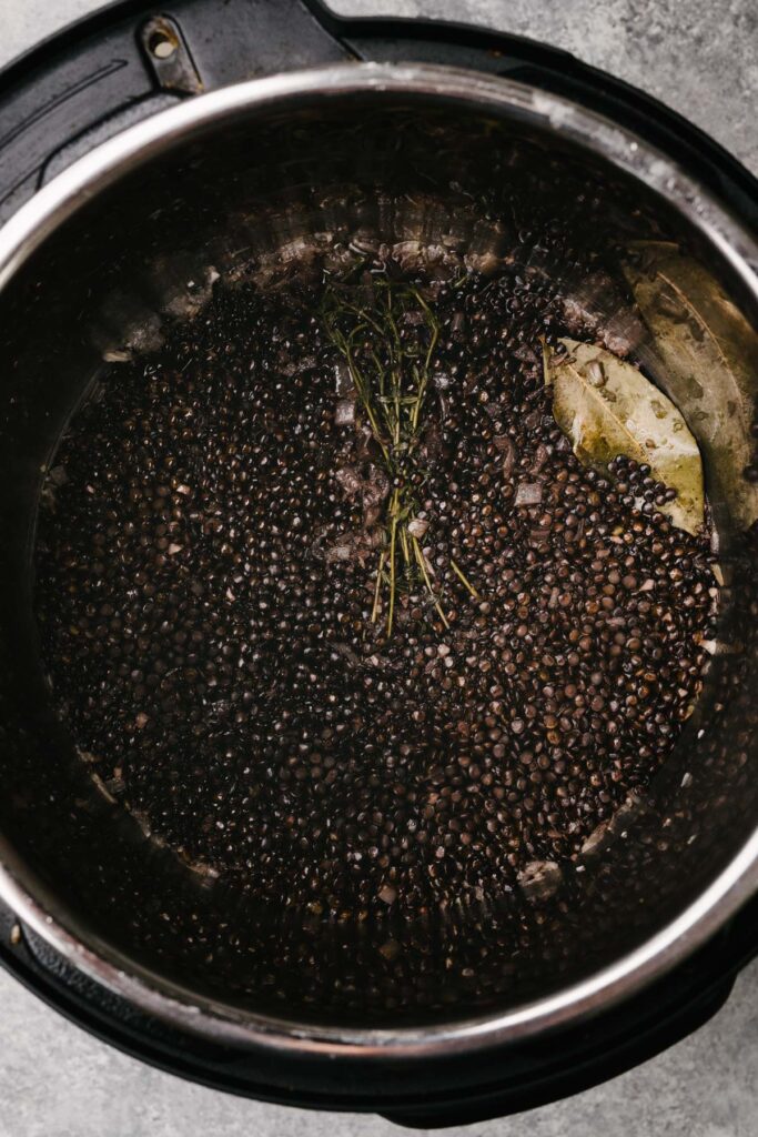 Cooked black lentils in and Instant Pot before draining the excess water.