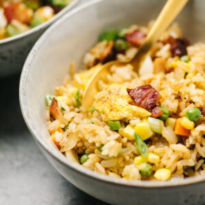 Side view, breakfast fried rice in a bowl with a gold spoon.