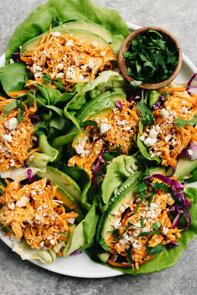 Overhead, low carb and keto buffalo chicken lettuce wraps on a white platter.