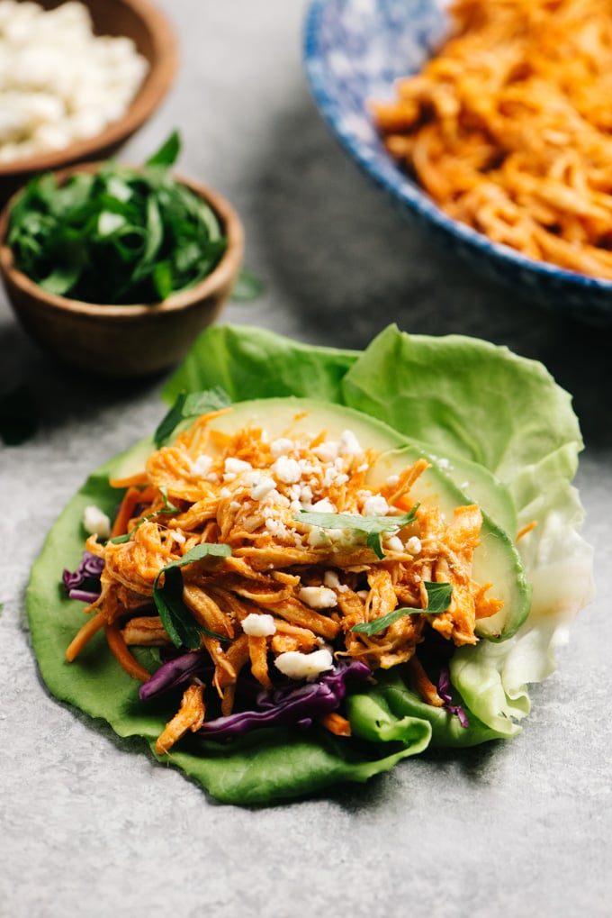 A prepared buffalo chicken lettuce wrap on a cement table top.