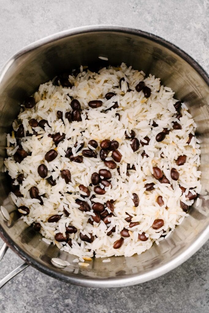 Steamed white rice with black beans in a saucepan.