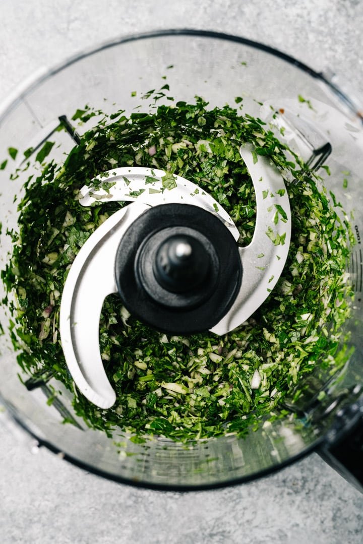 Minced herbs and garlic in a food processor.