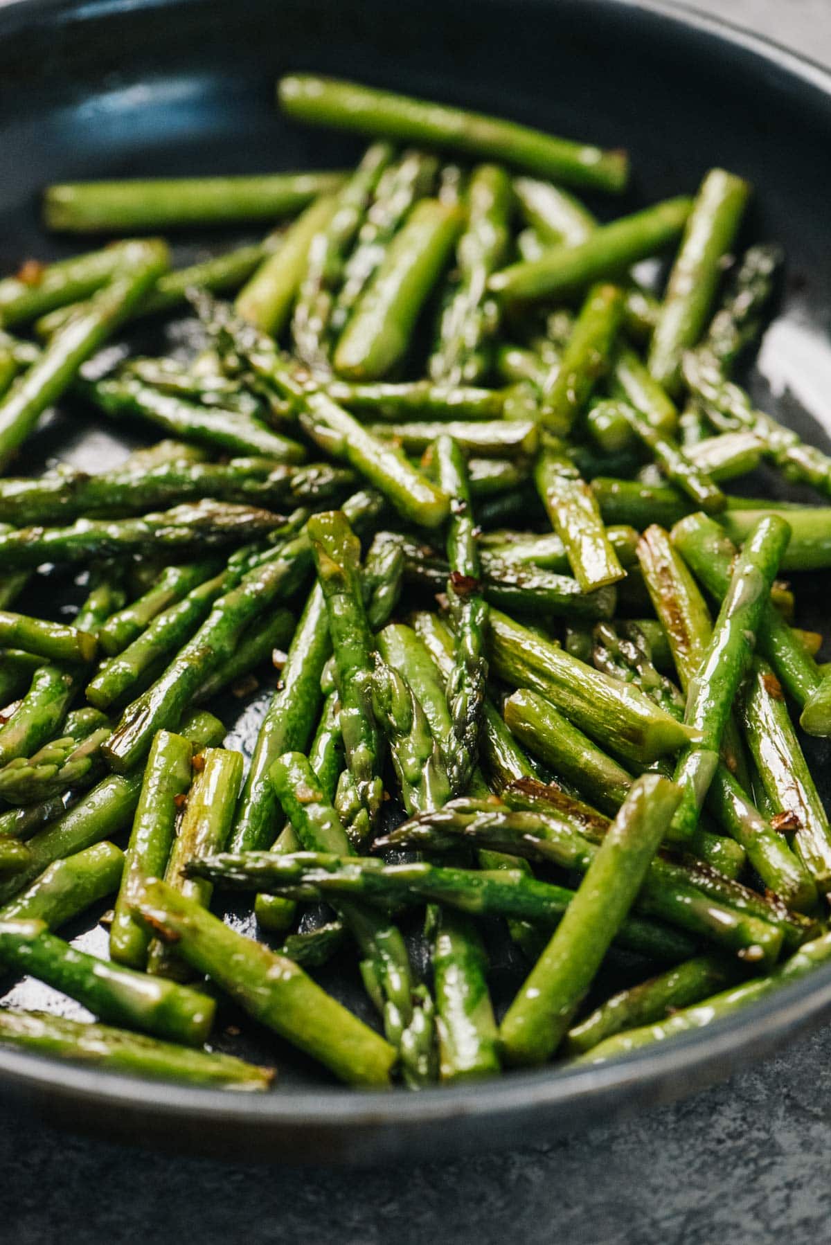 Side view, sautéed asparagus in a skillet.