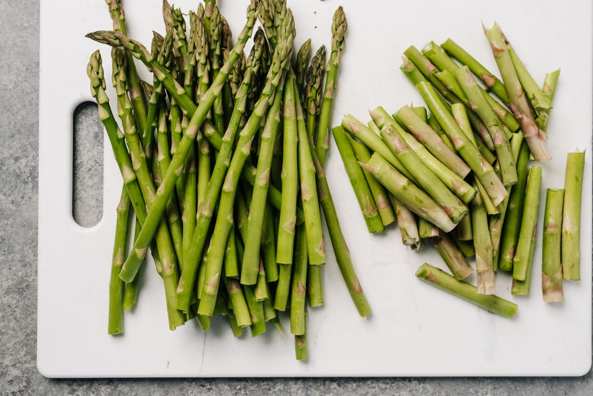 Trimmed asparagus spears on a white cutting board.