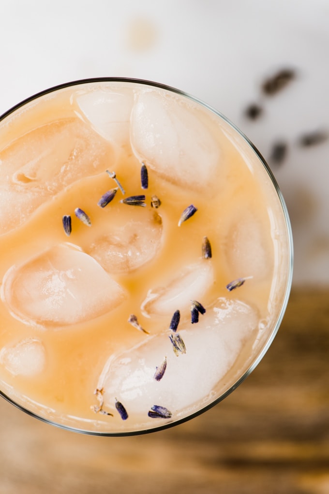 An overhead view of an iced london fog latte garnished with lavender leaves. A healthy, sugar free, dairy free ice tea latte recipe!