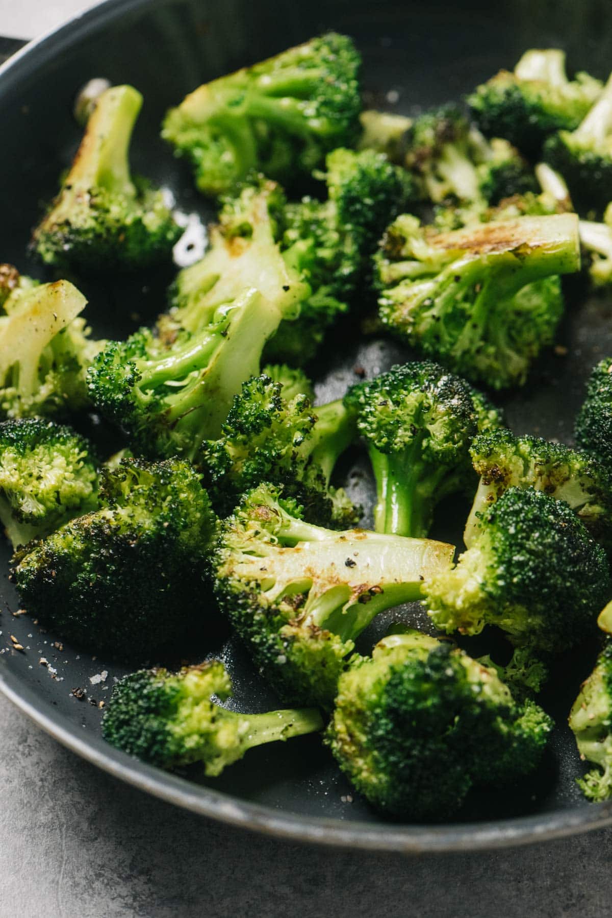 Side view, sautéed broccoli in a skillet with olive oil and garlic.