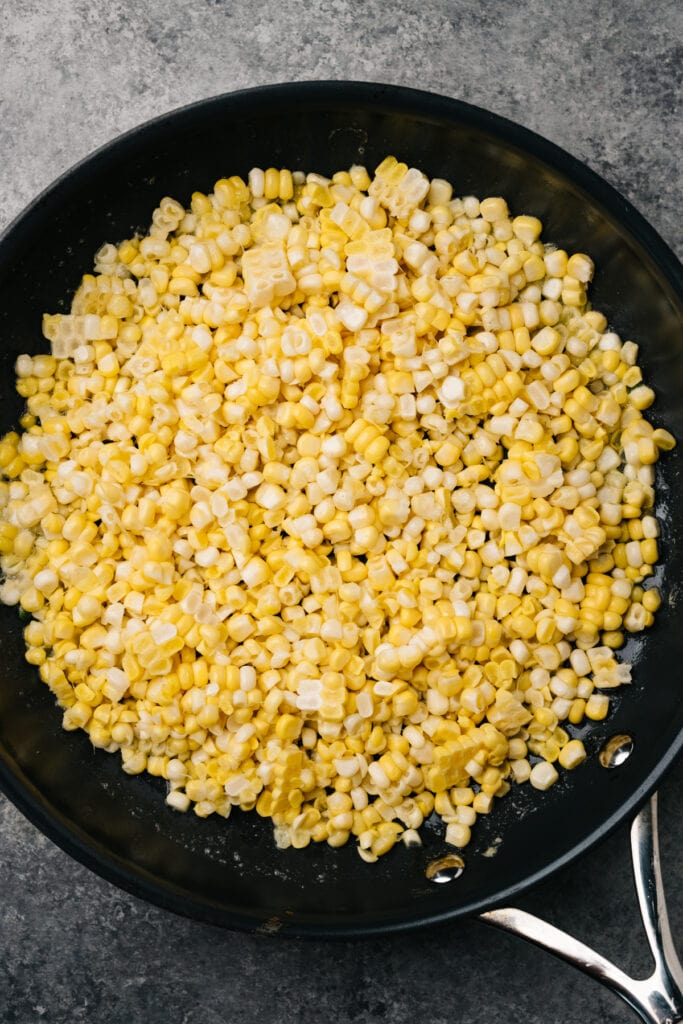 Raw corn kernels in a skillet.