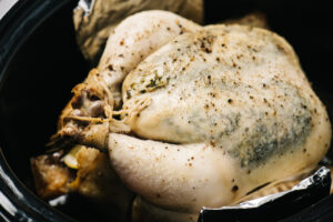 Side view, a cooked whole crockpot chicken.